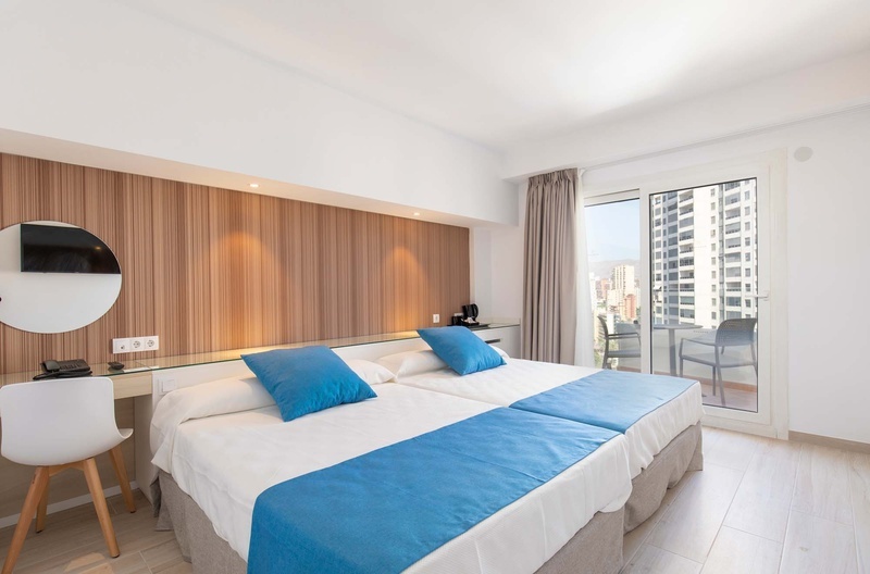 una habitación de hotel con dos camas y una mesa