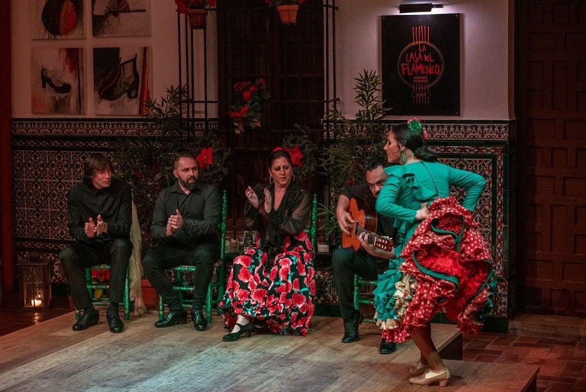 a balcony with a table and chairs and a tower in the background