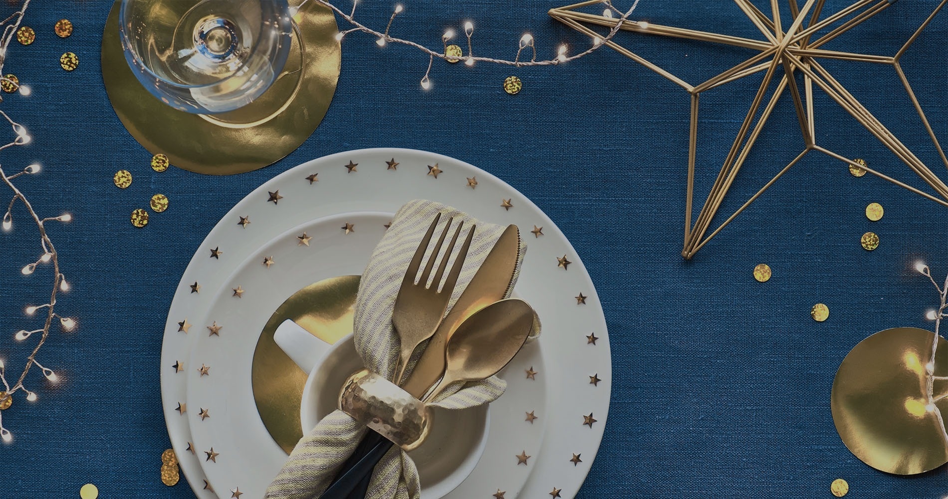 a place setting with plates and silverware with gold stars on them