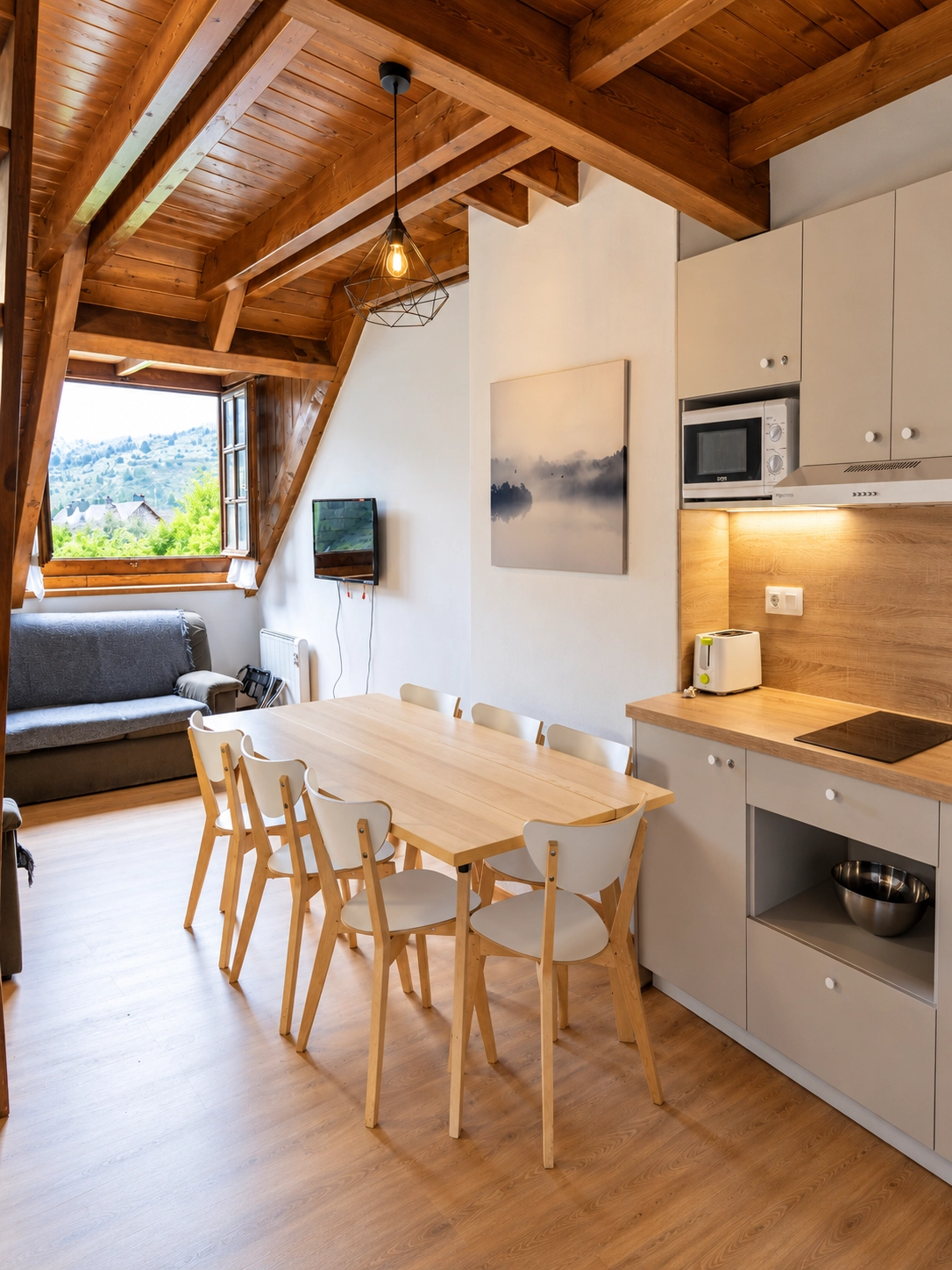 Comedor y cocina moderna SNO: Hotel Vall de Boi. Mesas de madera y sillas blancas.