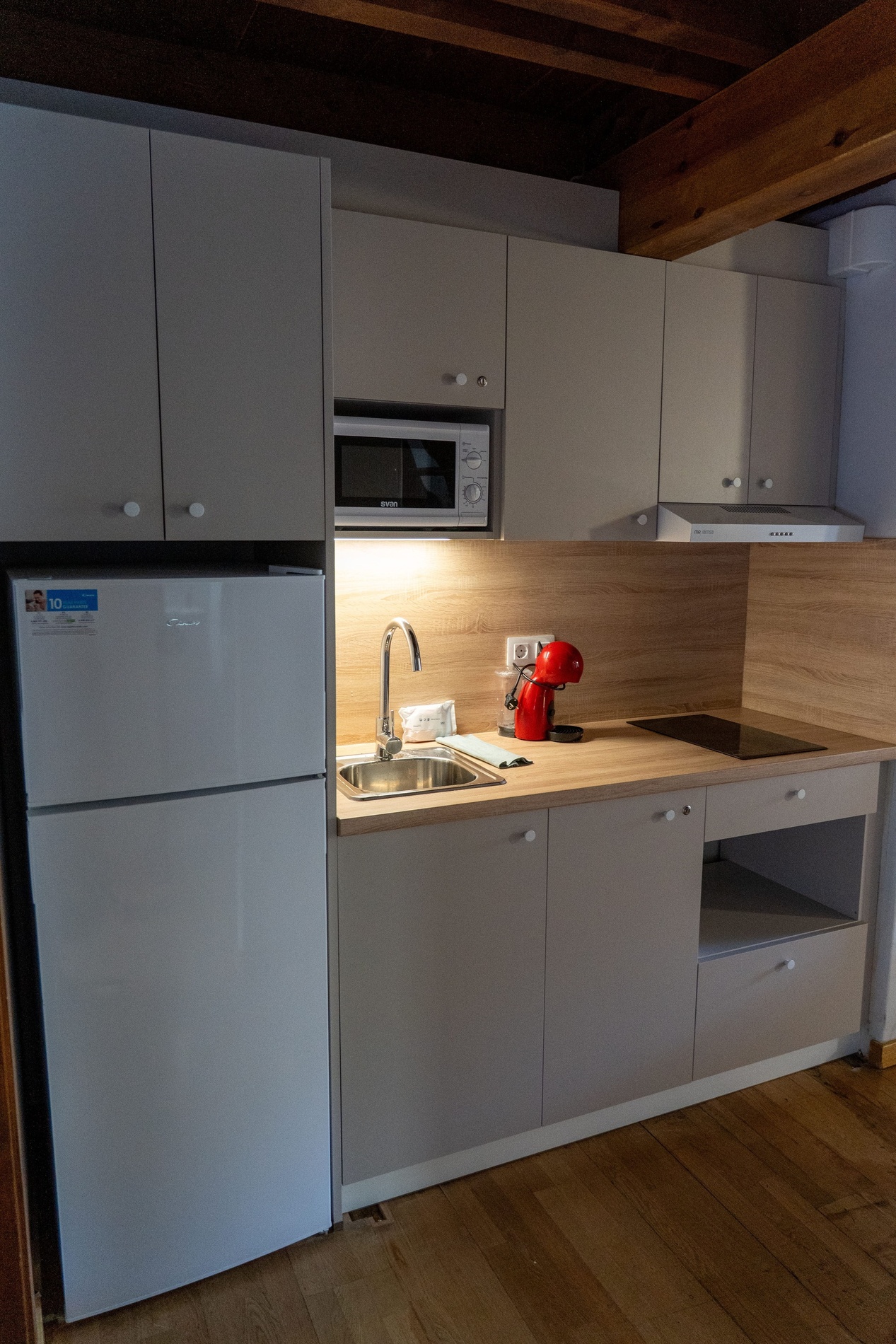 una cuina amb una nevera blanca i un microonda