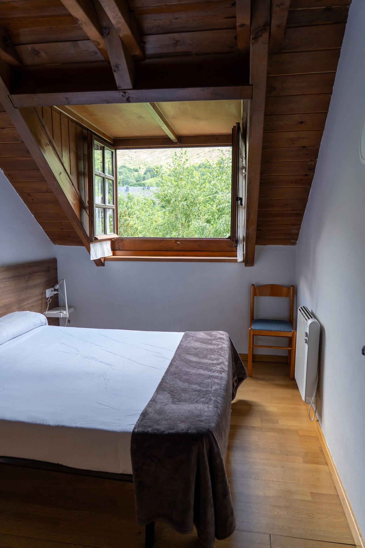 una habitación con una cama y una ventana abierta