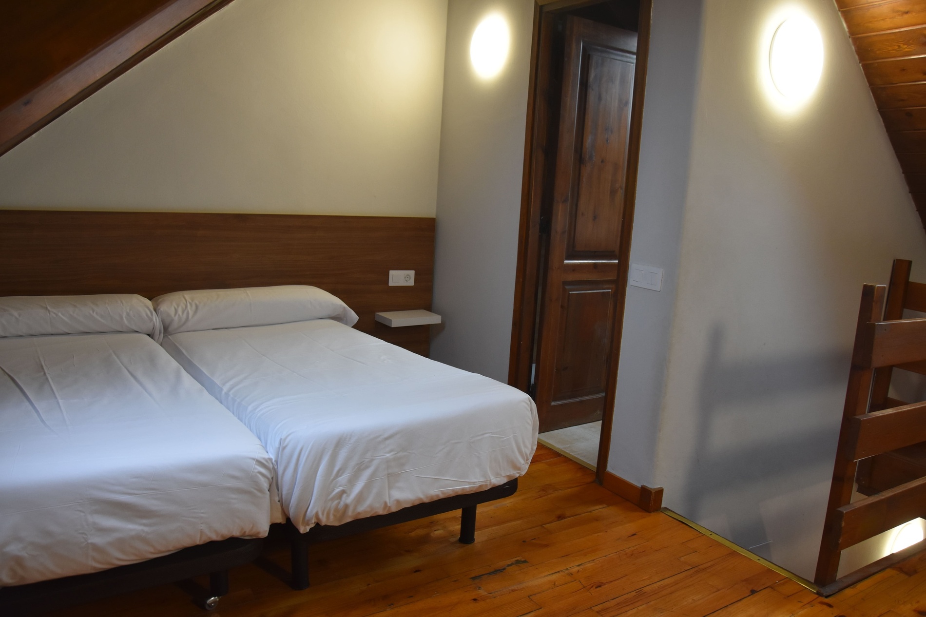 un dormitori amb duvets blancs i escales de fusta