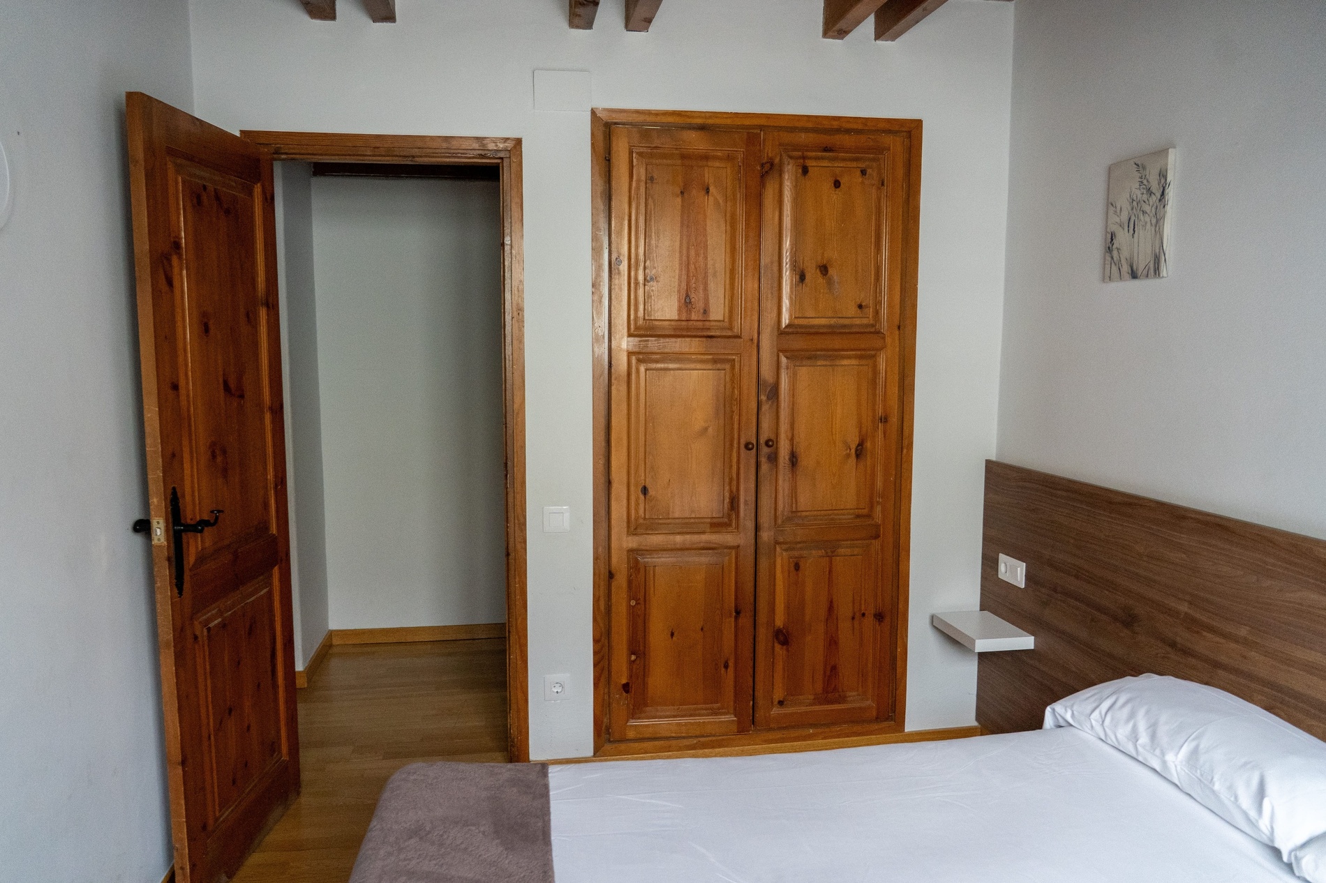 un dormitorio con una cama y un armario de madera