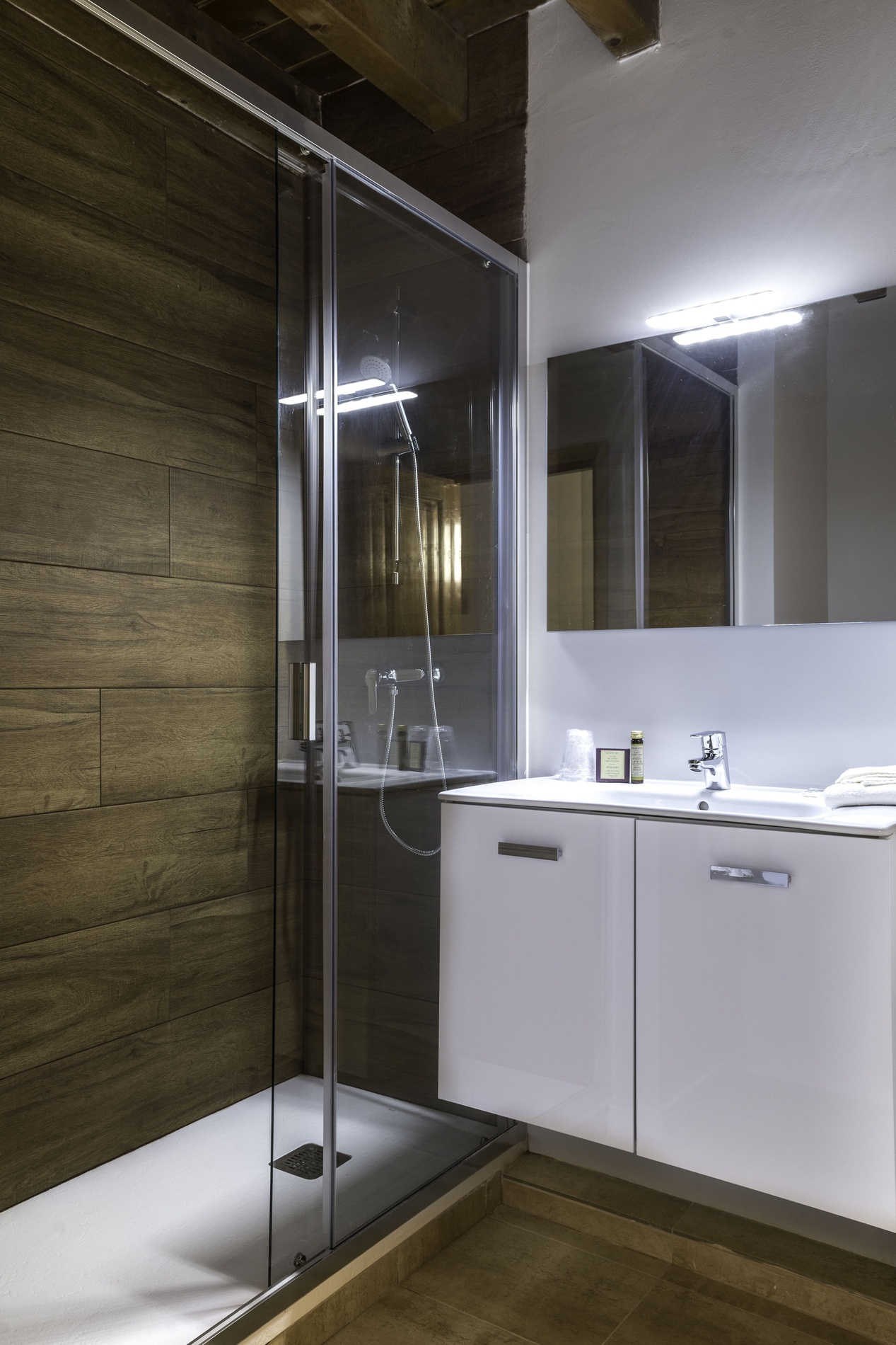 un bany amb dutxa , lavabo i mirall