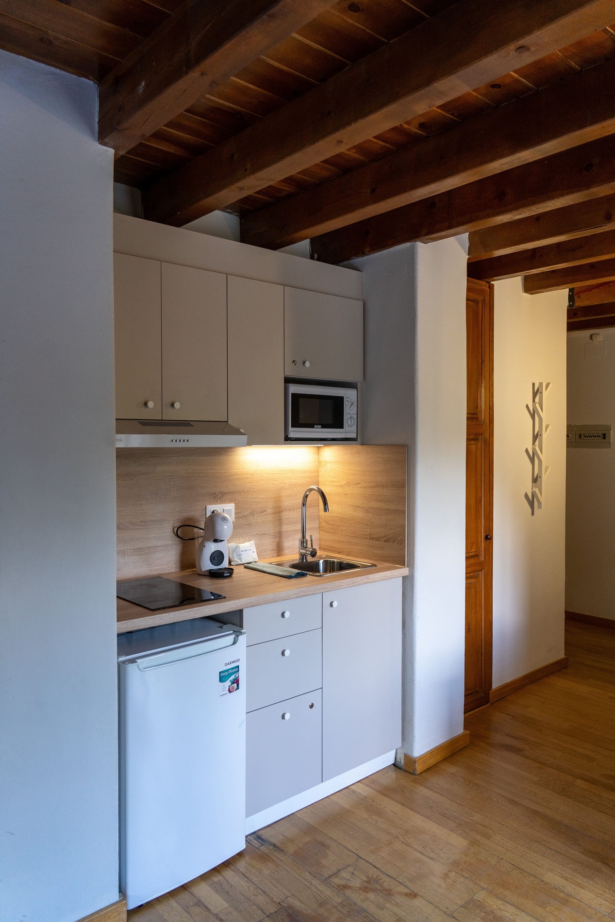 una pequeña cocina con una nevera y un microondas