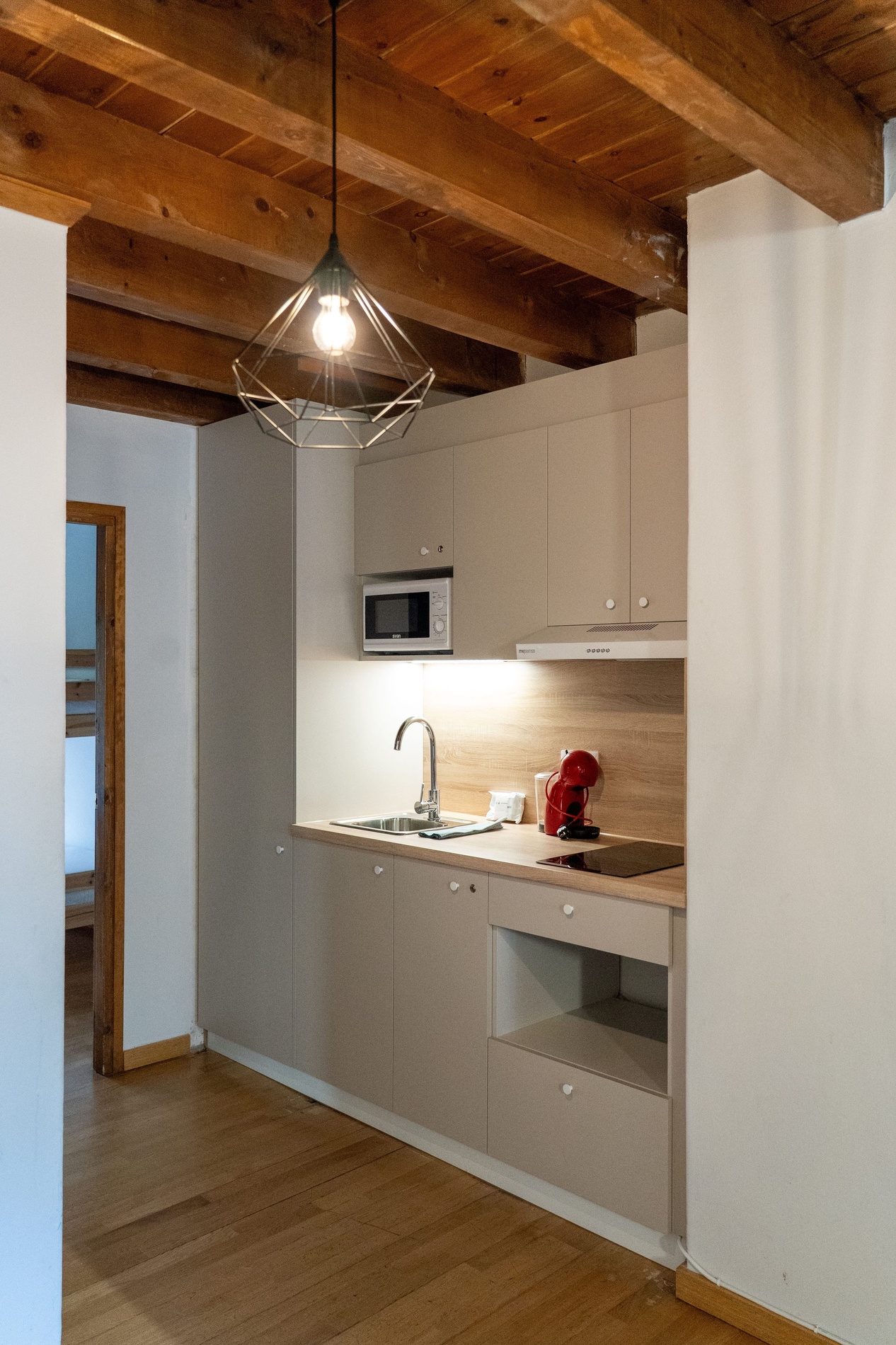 una cocina con gabinetes blancos y una estufa roja