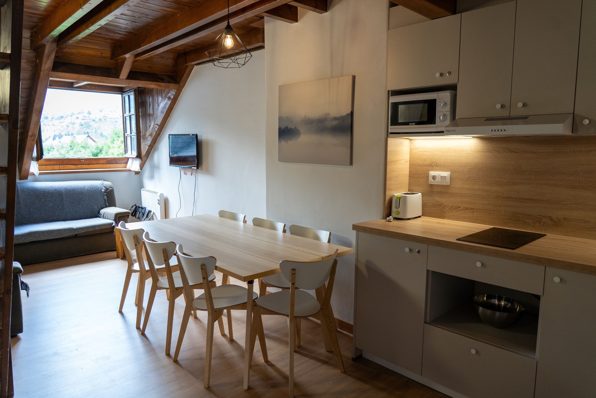 una cocina con una mesa y sillas y un microondas