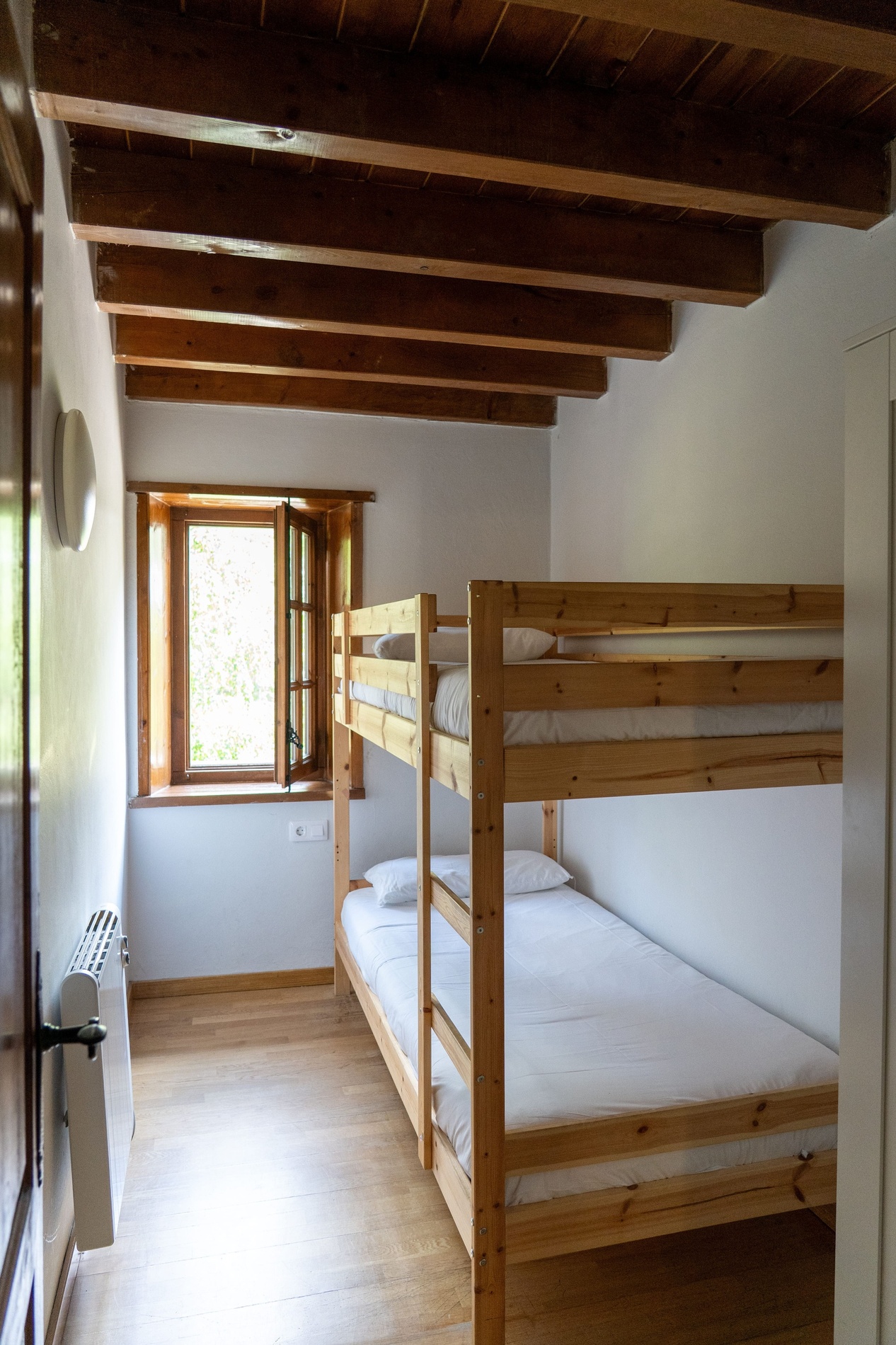 una habitación con dos literas de madera y una ventana
