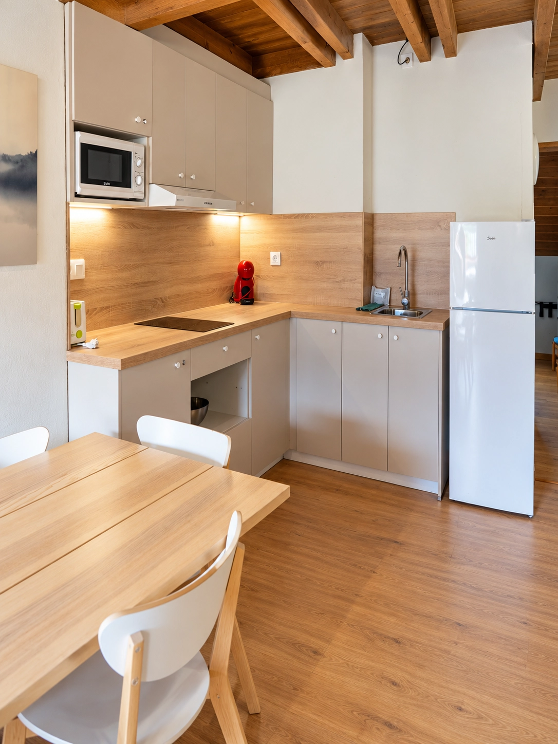 Pasillo SNO: Hotel Vall de Boi con vigas de madera y lámpara moderna.