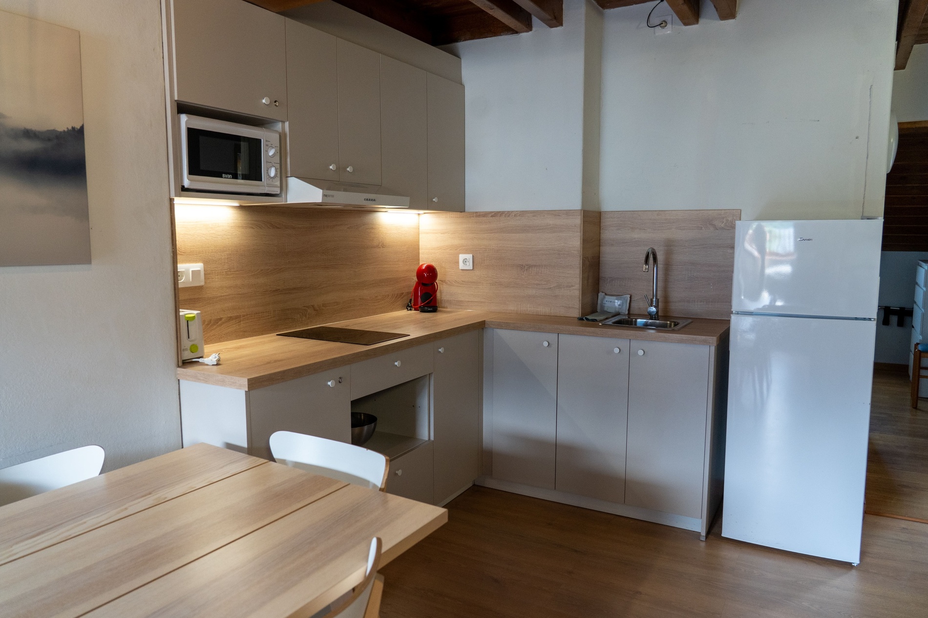 una cocina pequeña con electrodomésticos blancos y una nevera midea