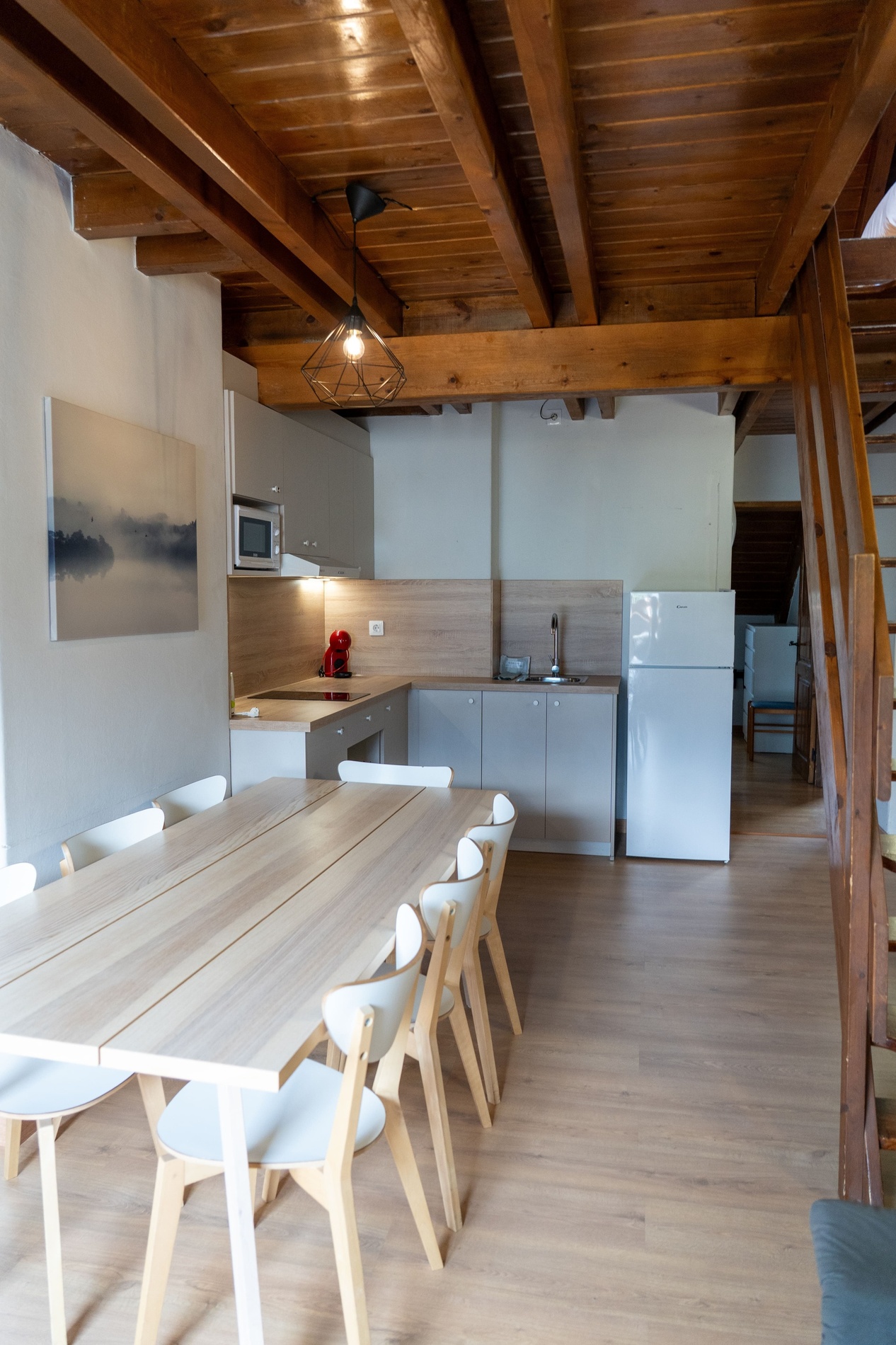 una cocina con una mesa y sillas y un refrigerador blanco