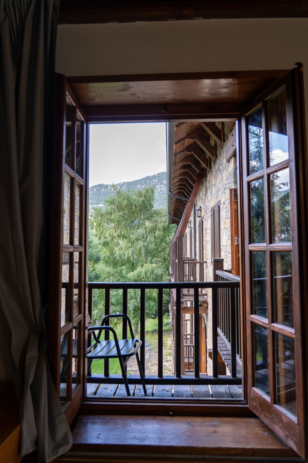 una ventana abierta que muestra una silla y un balcón