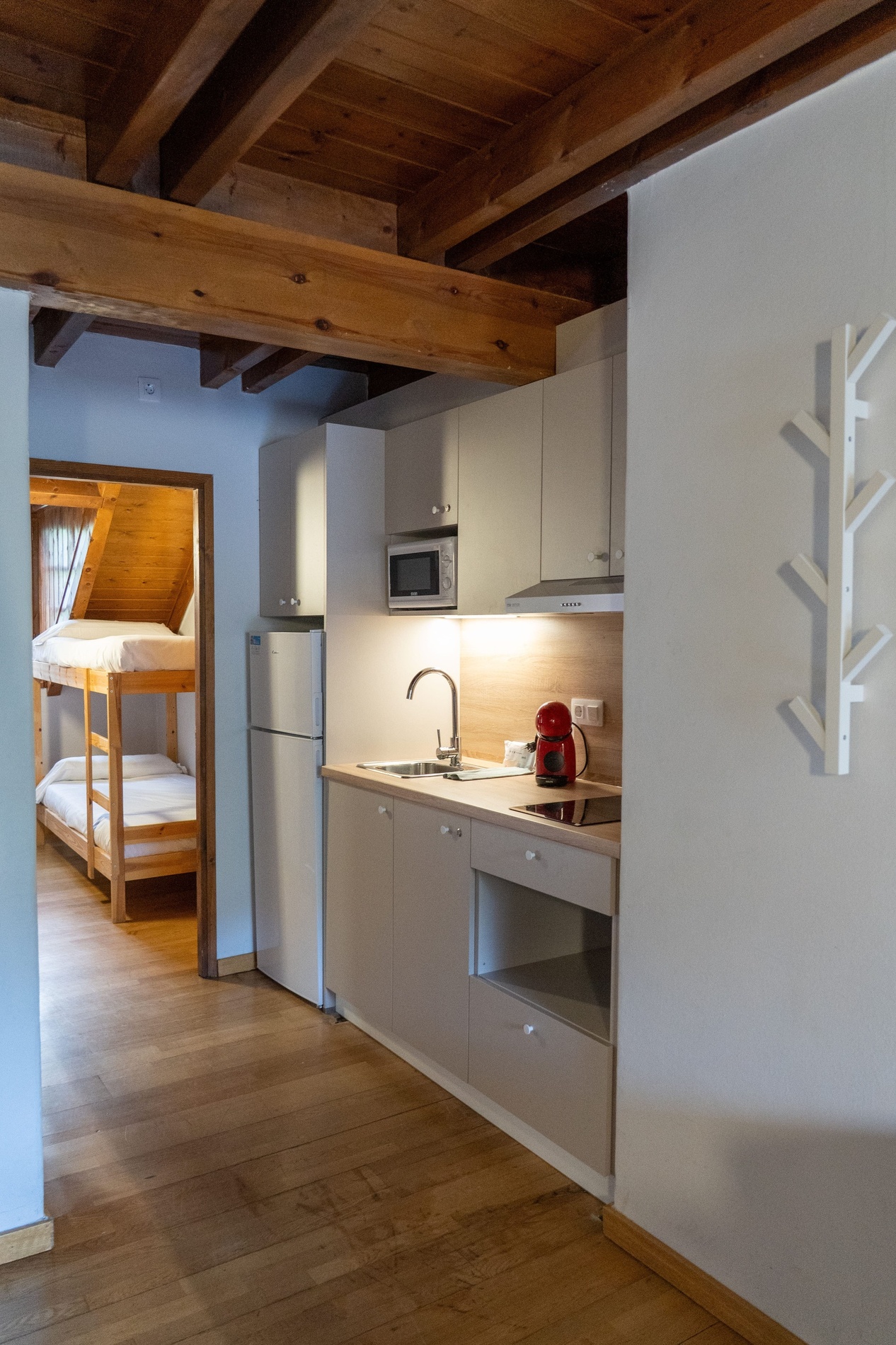 una cocina con muebles blancos y una máquina de café roja