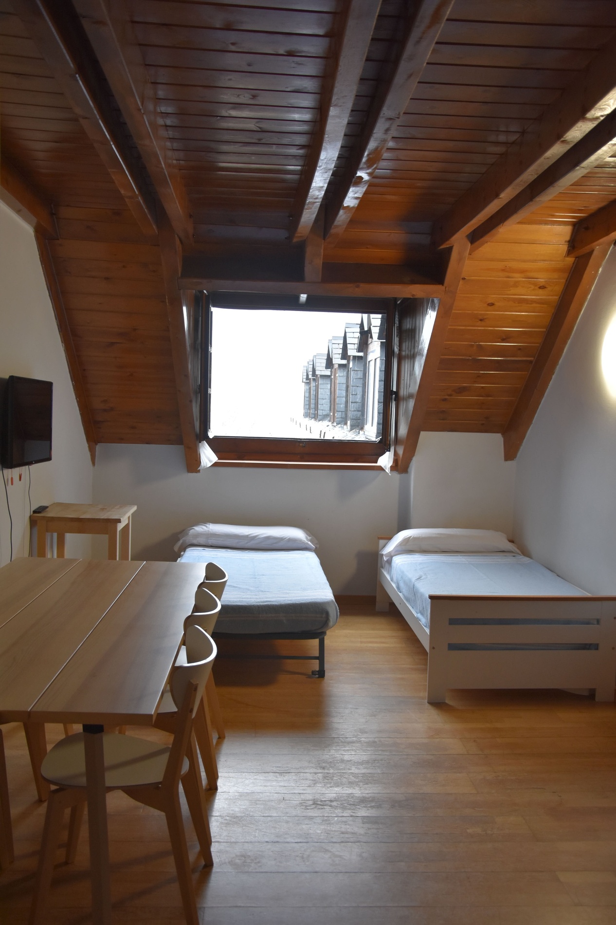 una habitació amb tres camas i una televisió