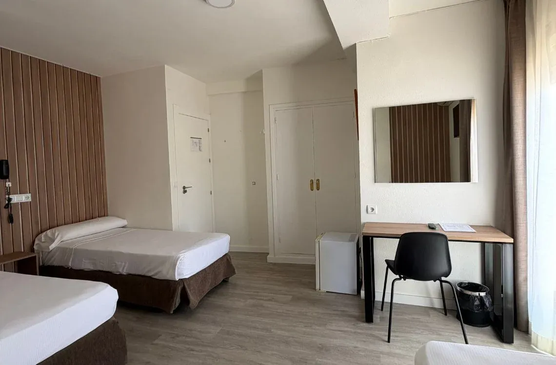 Habitación doble con literas, escritorio y espejo. Hotel Victoria Centro de hotel.