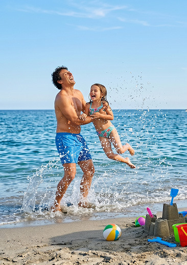 Padre e hija disfrutando sus vacaciones en la playa.