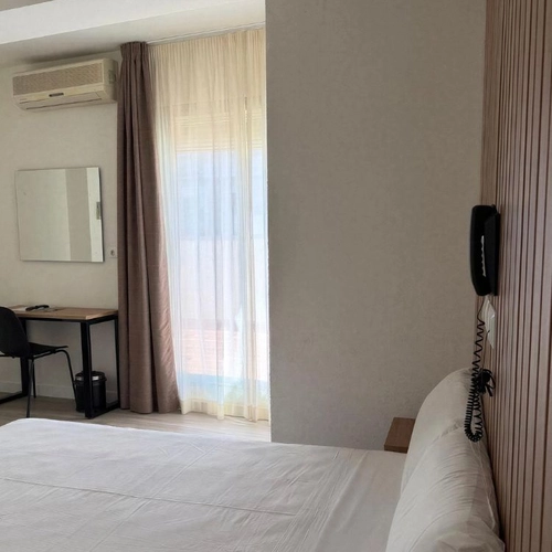 Habitación de hotel con cama, escritorio y Hotel Victoria Centro.