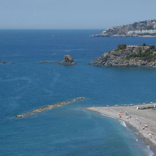 Playa y mar azul con islas y un hotel costero, ideal para tu Hotel Victoria Centro.