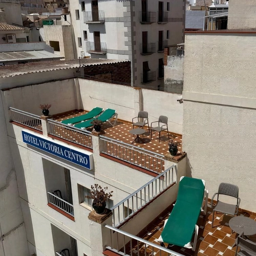 Terraza con tumbonas y vistas al HOTEL VICTORIA CENTRO, un lugar ideal para descansar y disfrutar. Hotel Victoria Centro