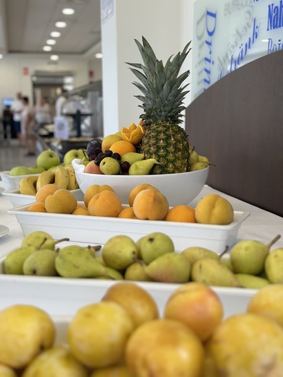 a bowl of fruit sits in front of a sign that says drink