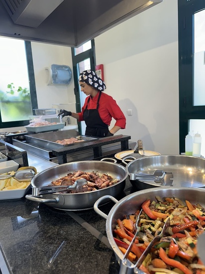 una mujer prepara comida en una cocina llena de platos de comida