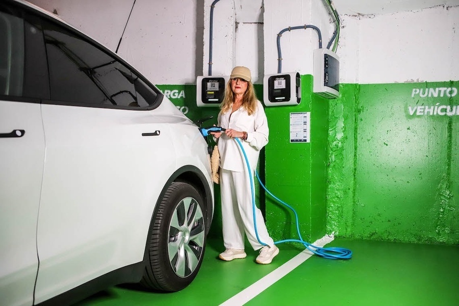 una mujer está cargando un coche eléctrico en un punto de recarga