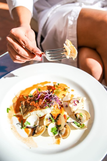 a person is holding a fork over a plate of food