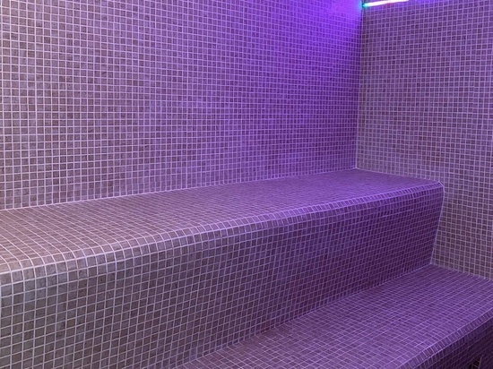 una habitación con baldosas moradas y luces moradas