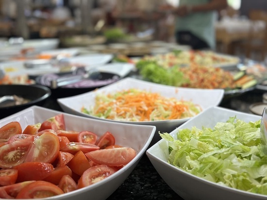 bowls of tomatoes and lettuce are on a table