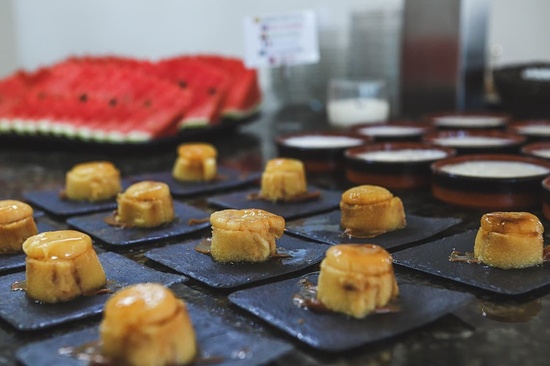 a bunch of desserts on a table with watermelon in the background