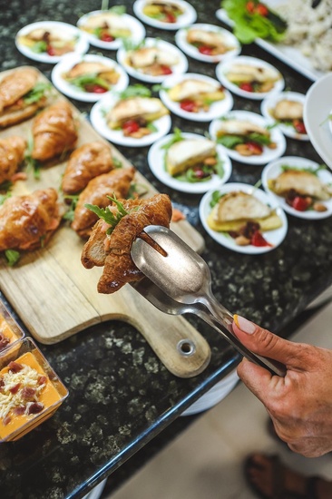 a person is holding a tong over a piece of food