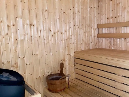 un cubo de madera está sentado en una sauna de madera