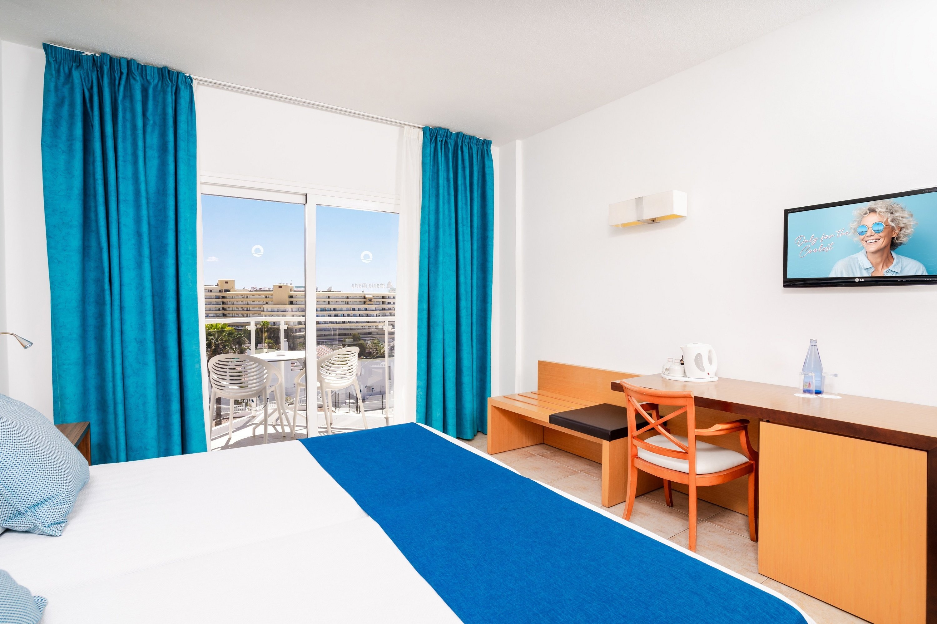 a hotel room with a large bed and blue curtains