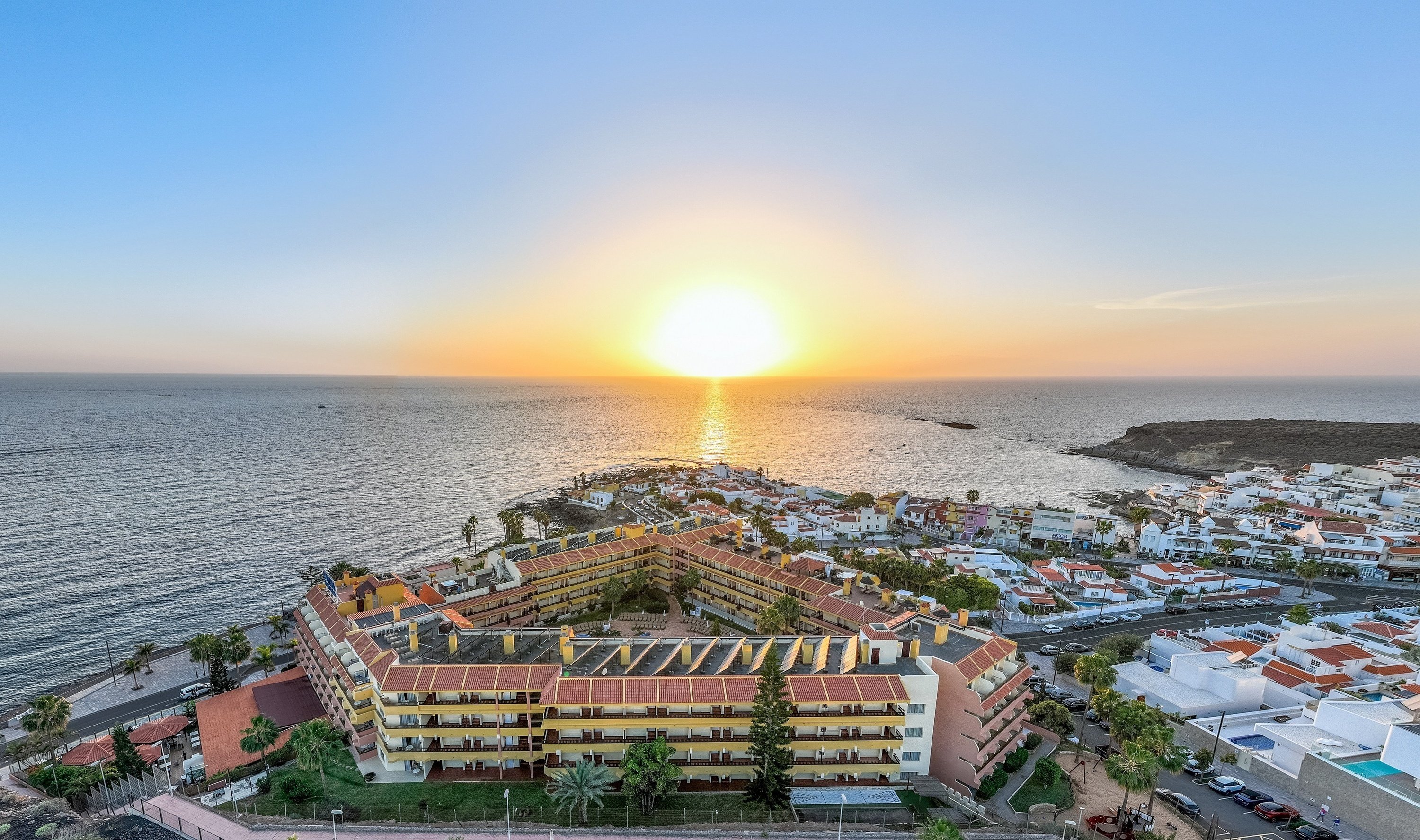 una bebida roja con una pajita en la playa