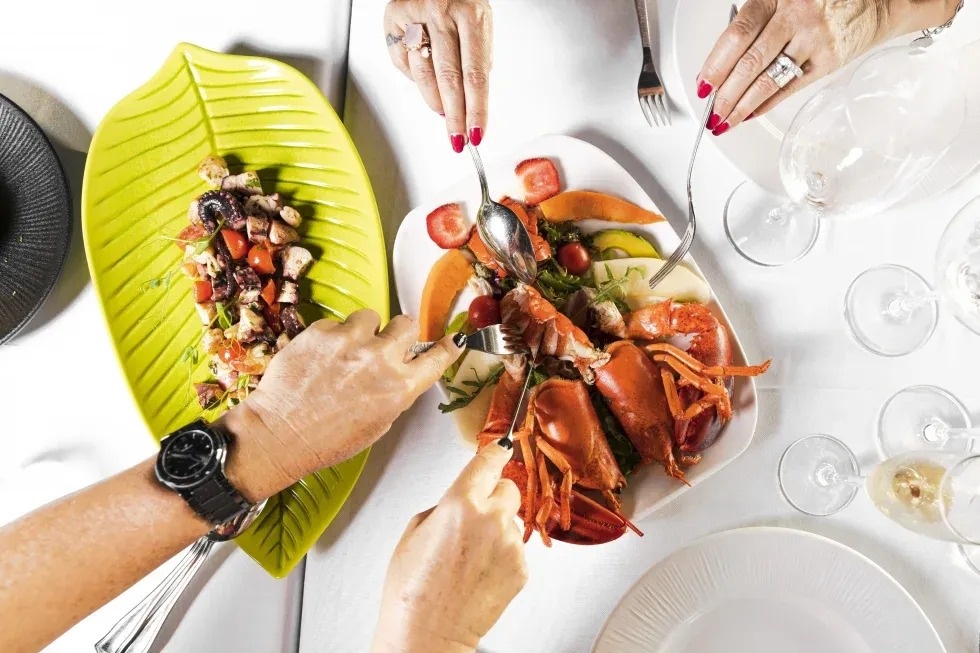 de zon schijnt door de bomen boven een stad met uitzicht op de oceaan