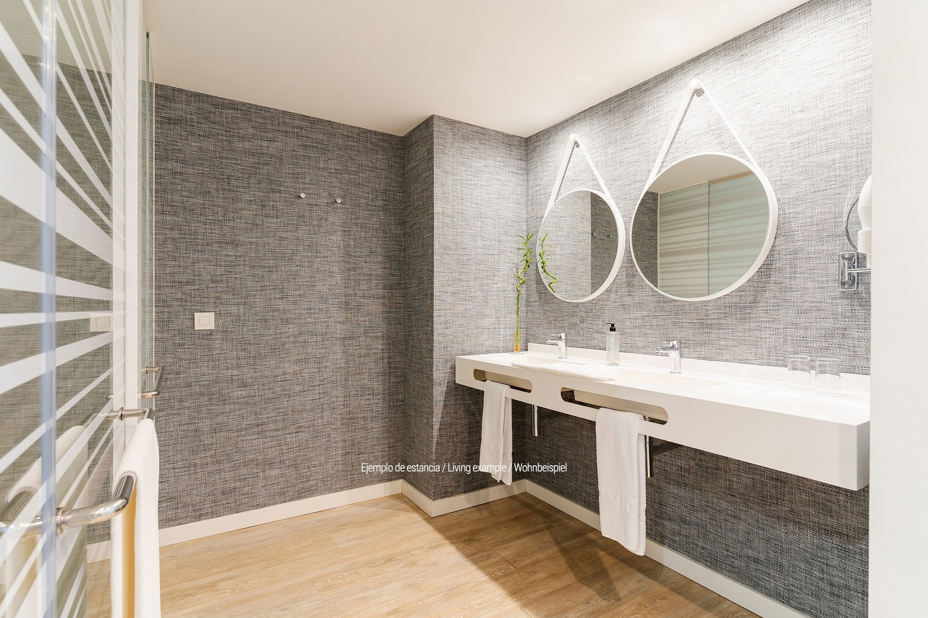 a bathroom with two sinks and two round mirrors