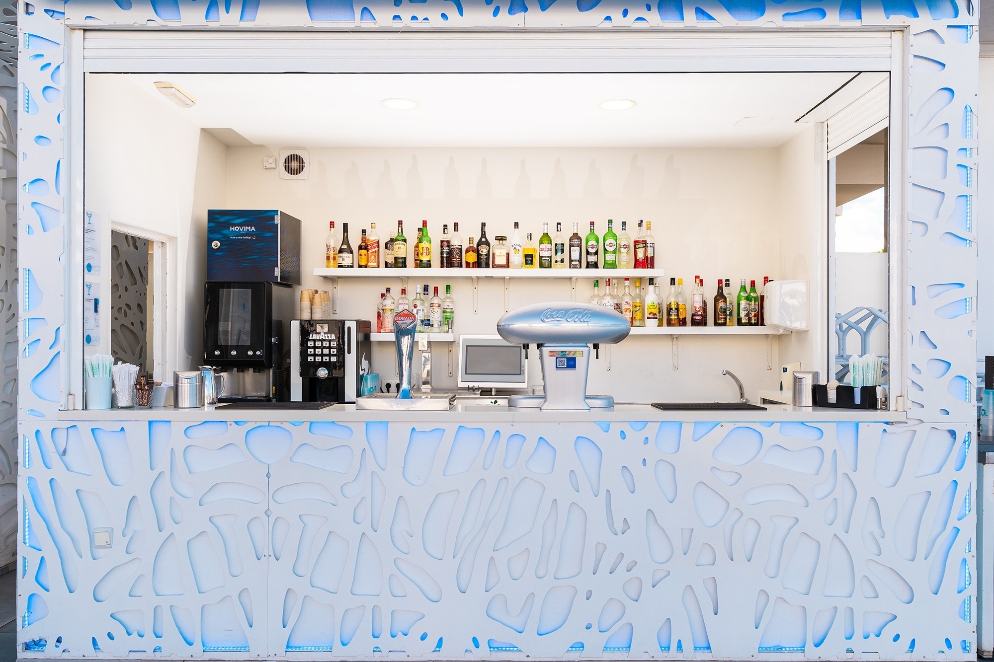 un bar avec une machine à café et des bouteilles de boissons