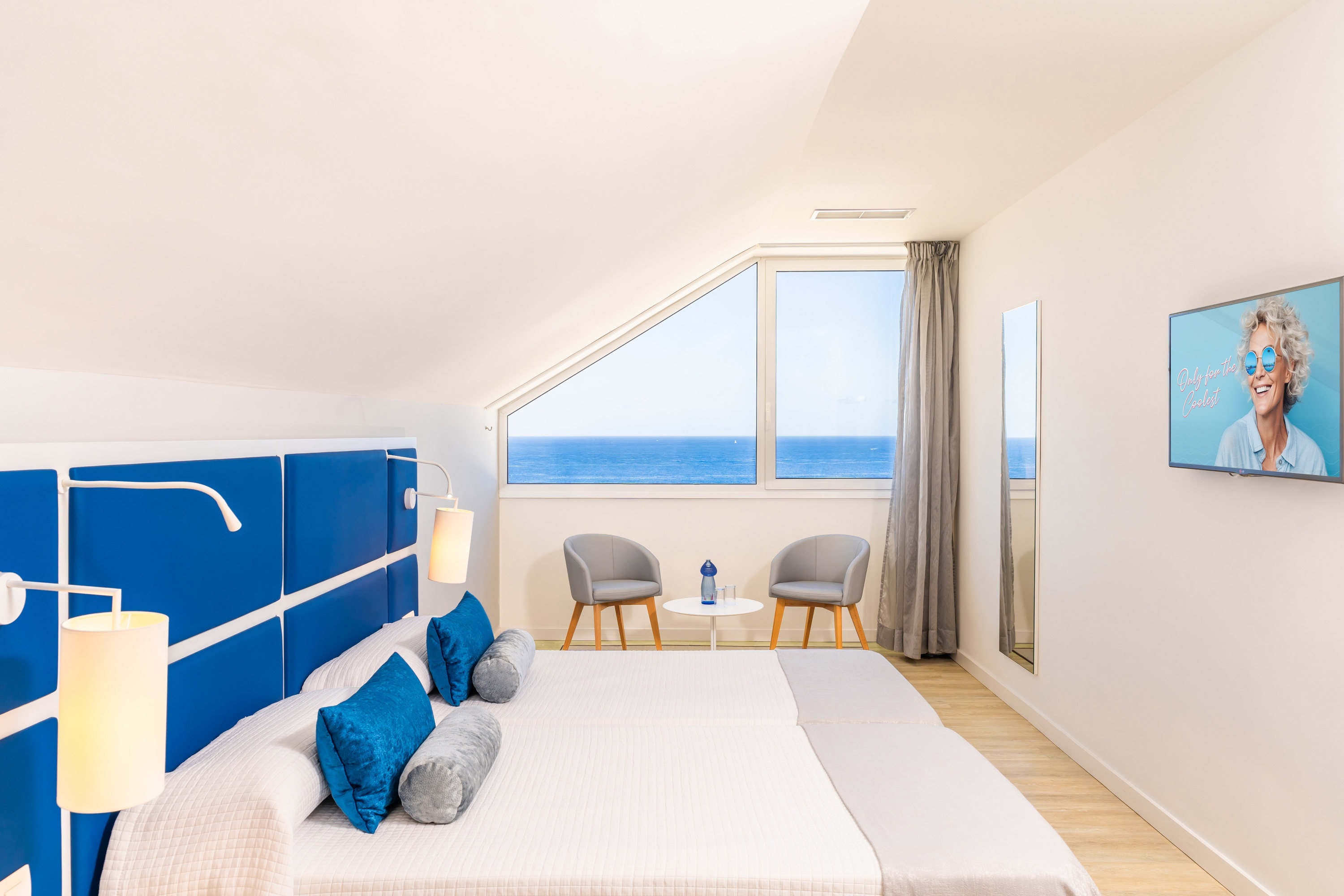 a bathroom with two sinks and two round mirrors