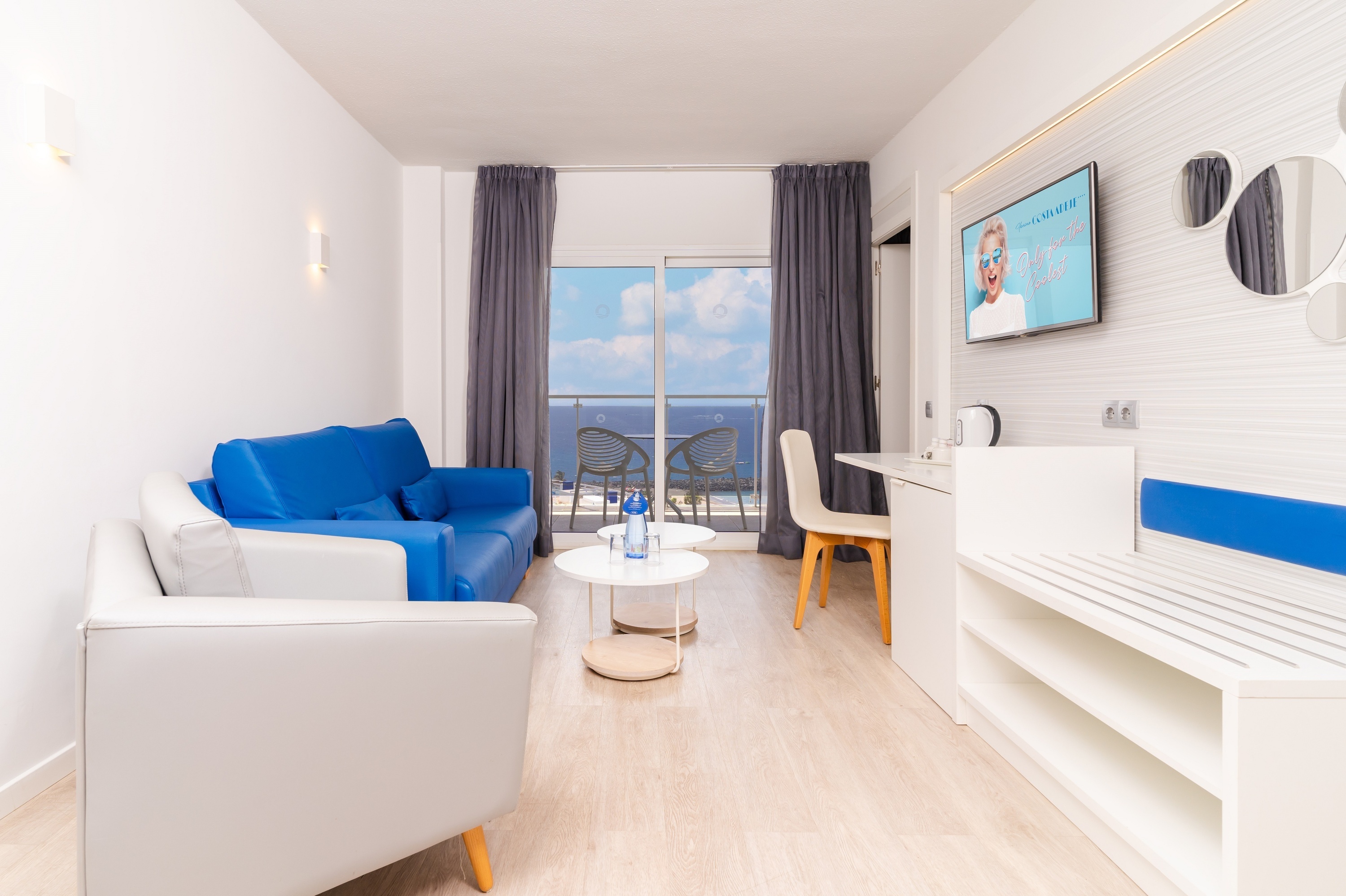 a living room with a blue couch and a white chair