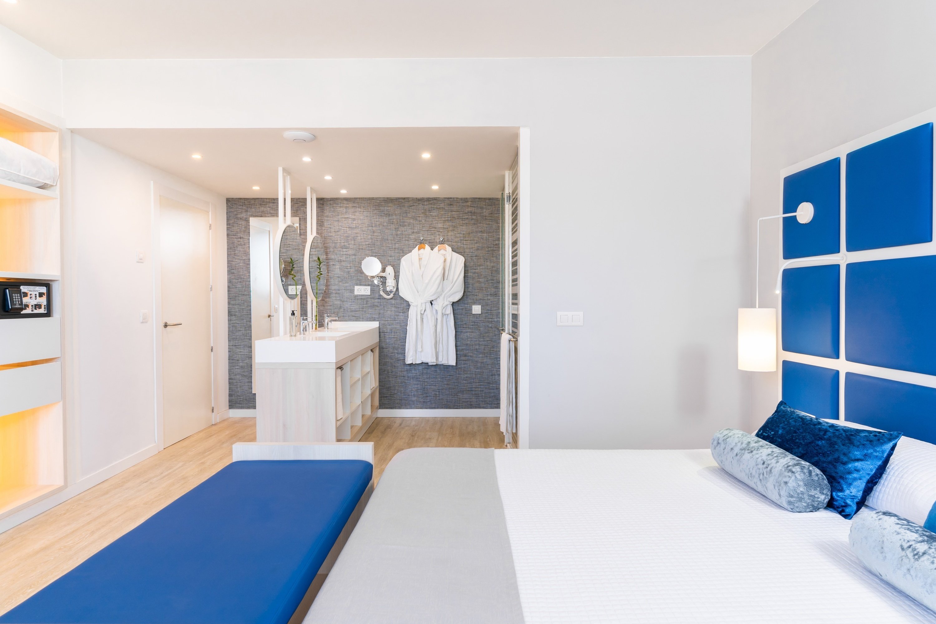 a hotel room with a bed and a blue bench