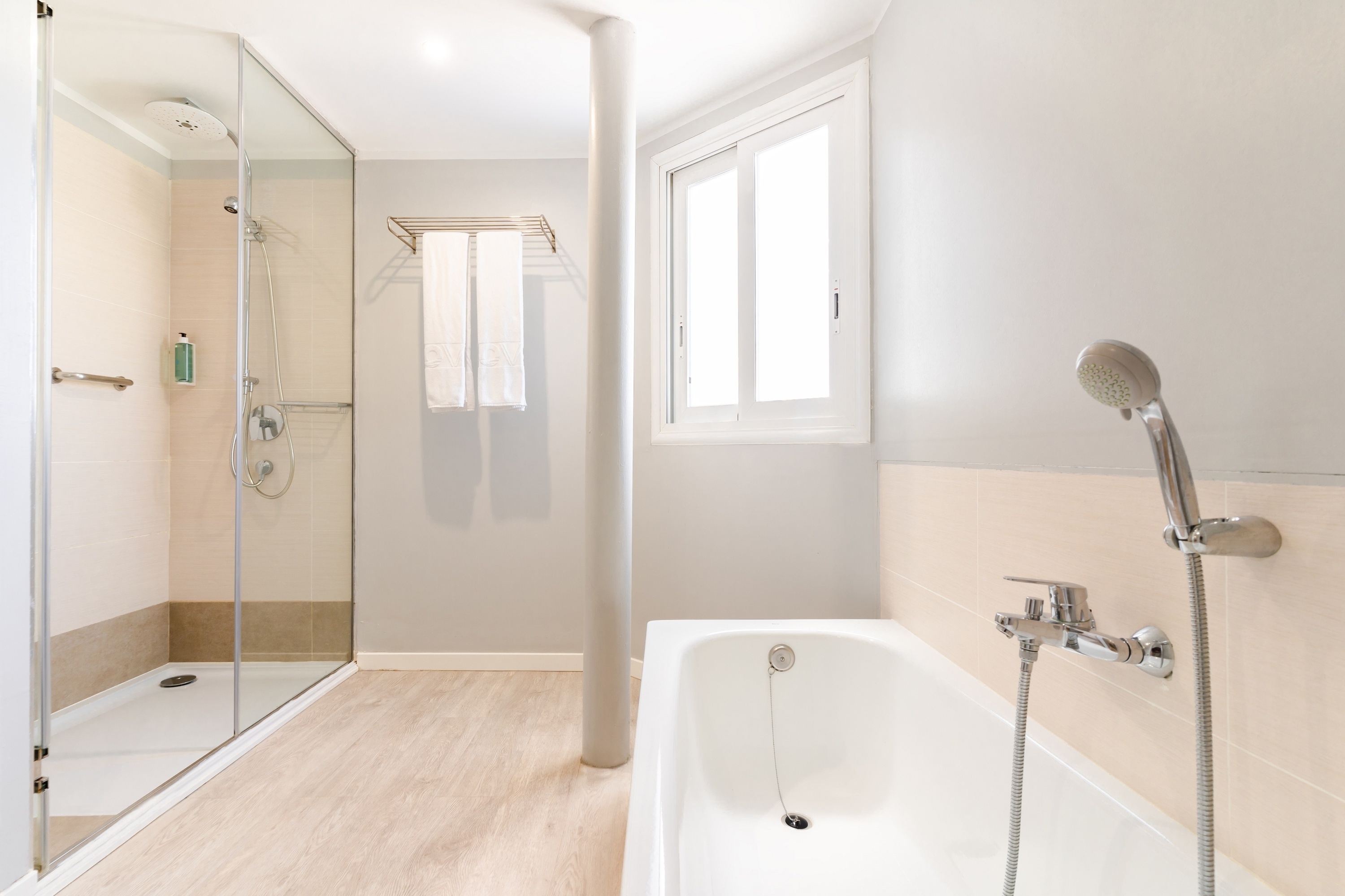 a bathroom with a bathtub shower and window