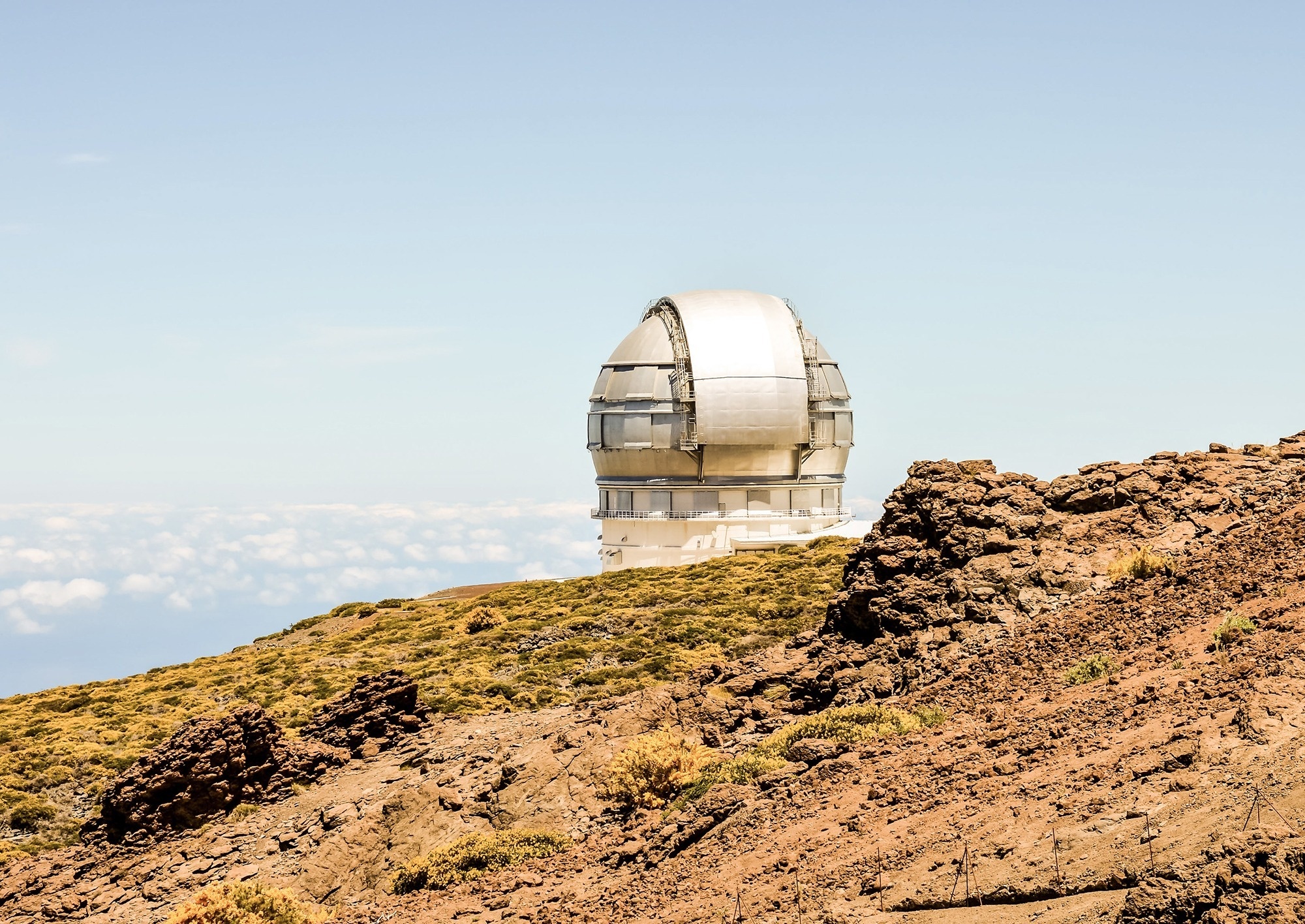 
                                    большой серебряный телескоп стоит на вершине скалистого холма