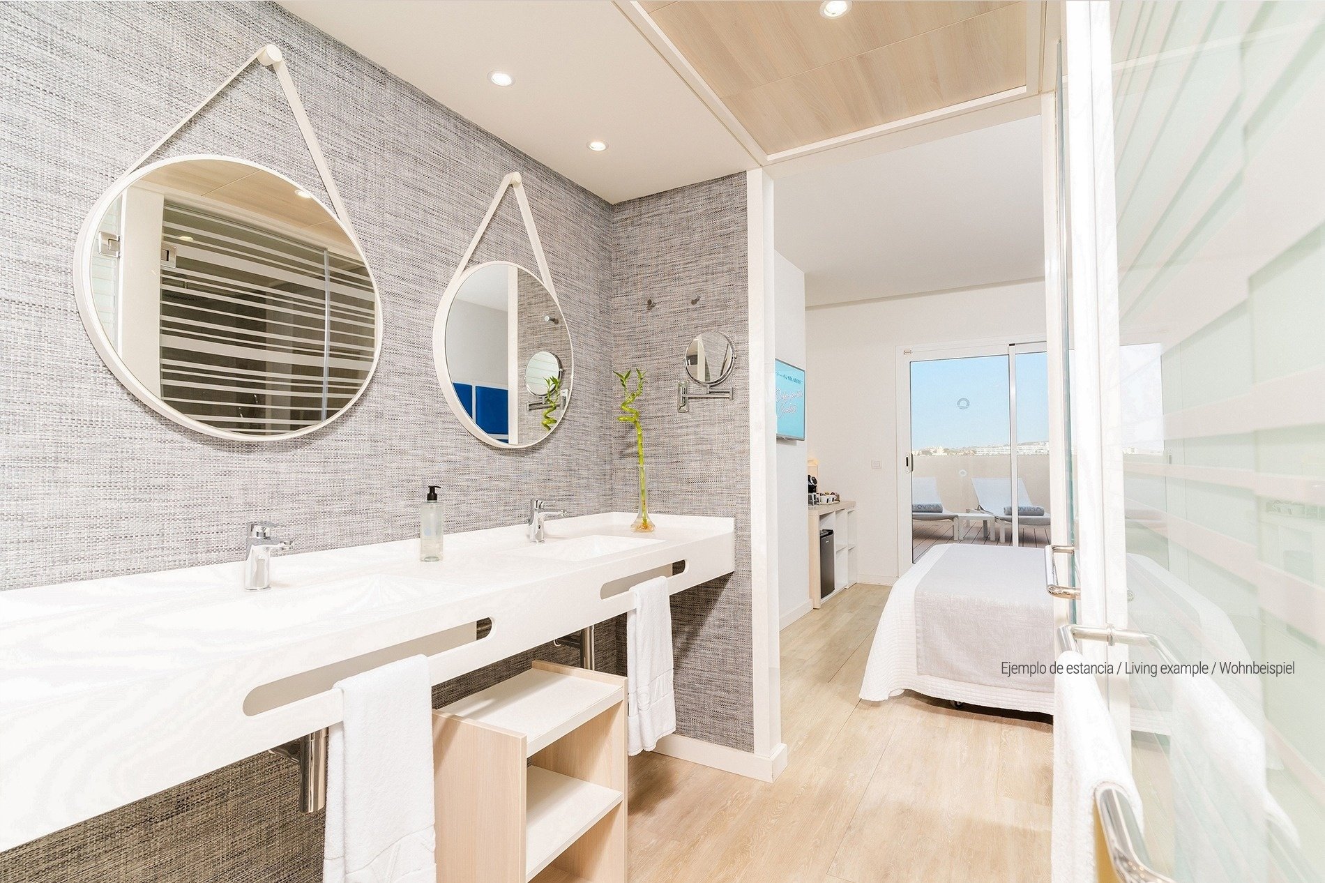 a bathroom with two sinks and two round mirrors