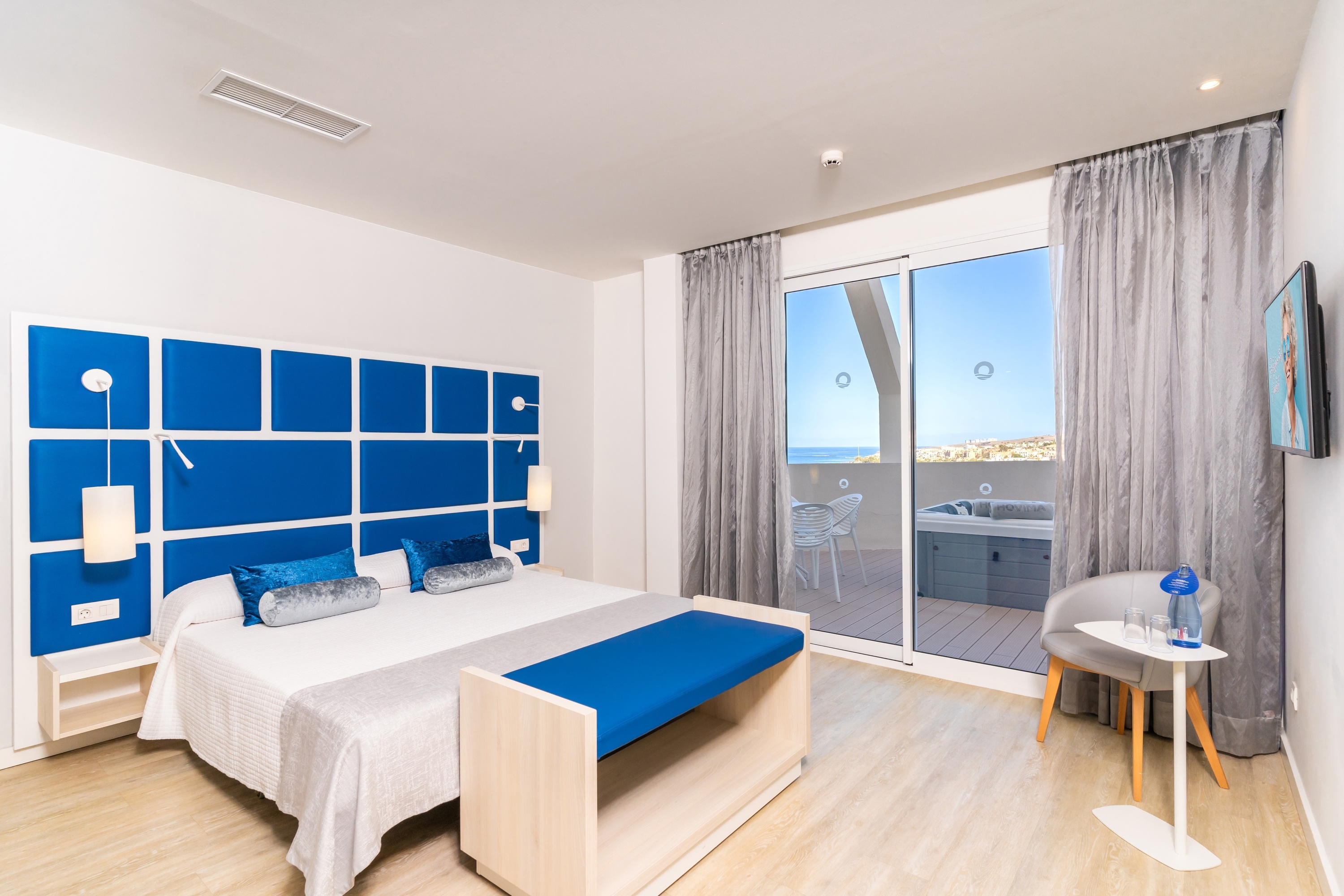 a hotel room with a large bed and a sliding glass door