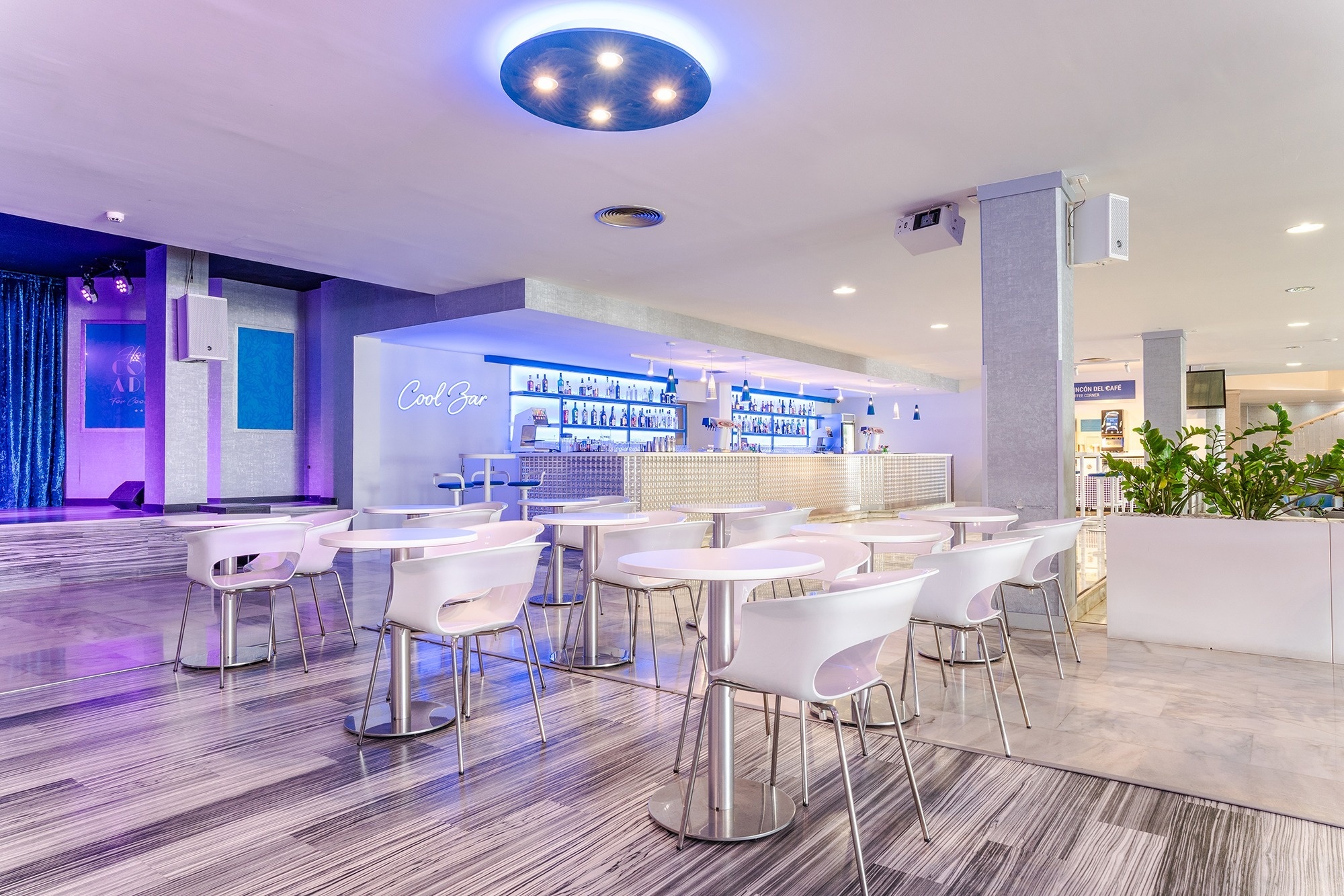 une salle avec des tables et des chaises et un bar qui dit cool bar