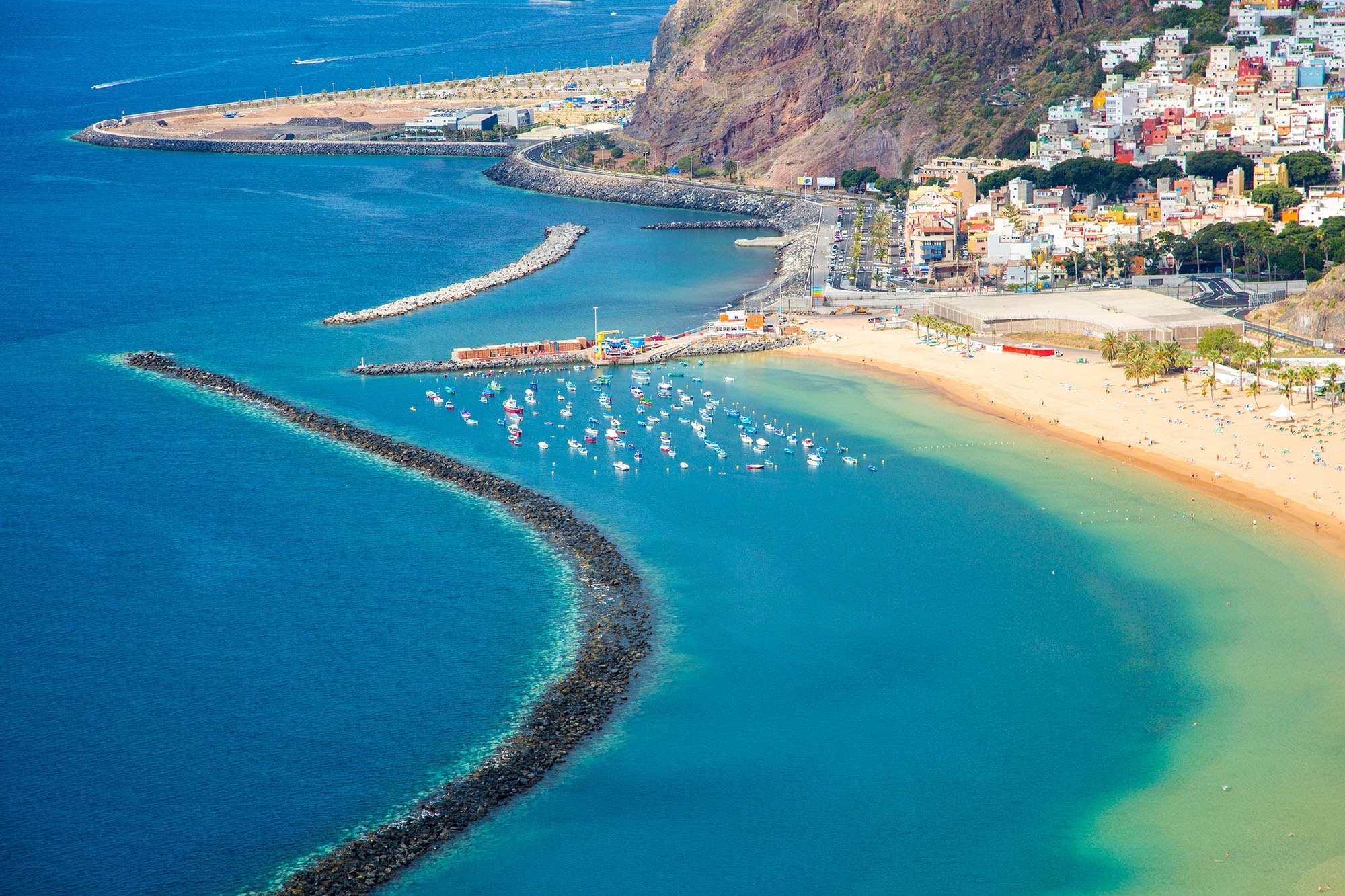 
                                    boats are docked in a harbor near a beach