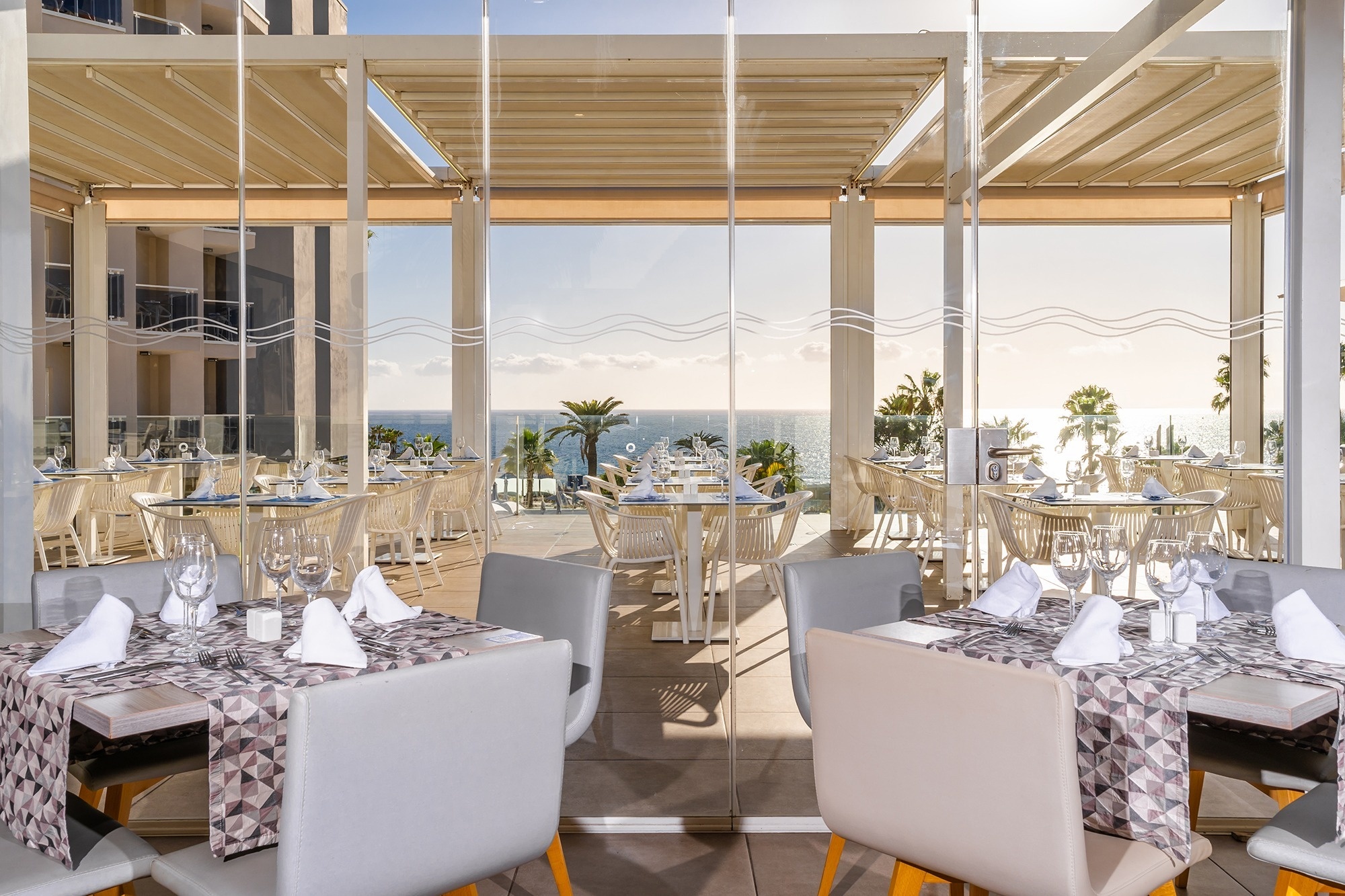 
                                    een restaurant met tafels en stoelen met uitzicht op de oceaan