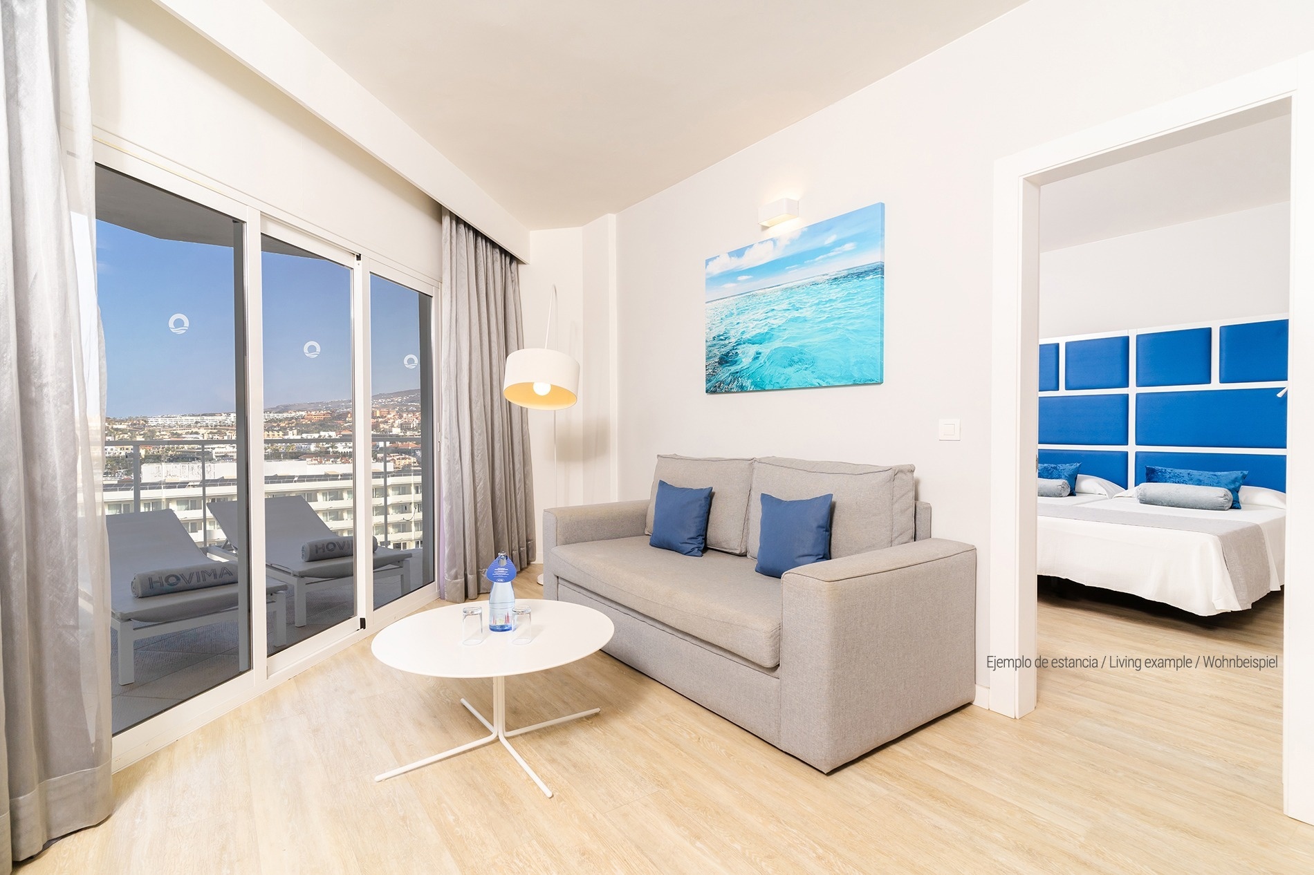 a living room with a blue couch and two white tables