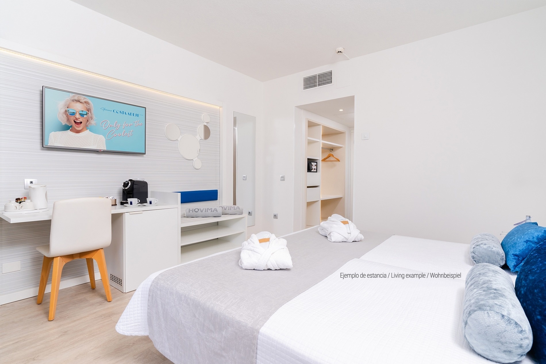 a hotel room with two beds and a blue headboard